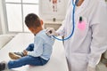 Mother and son pediatrician and patient auscultating respiratory system at clinic Royalty Free Stock Photo