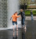 Mother and son play barefoot in Crown Fountain, Chicago