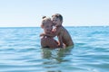 Mother and son playing on the beach in the day time. Portrait of happy little kid boy on the beach of ocean. Funny cute child maki Royalty Free Stock Photo