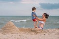 Mother and son playing on the beach at the sunset time. Concept of friendly family Royalty Free Stock Photo