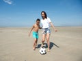 Mother and son playing football on the beach Royalty Free Stock Photo