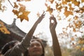 Mother and son reaching for a leaf on a branch in the autumn Royalty Free Stock Photo