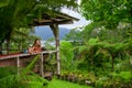 Mother, son relaxing on veranda with tropical garden view Royalty Free Stock Photo