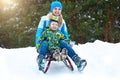 Mother and son ride on sleigh .Child play in snowy forest. Outdoor winter fun for family Christmas vacation. Royalty Free Stock Photo