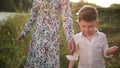 Mother with son at river, throwing rocks, young family on the walk. Teaching