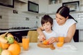 Mother and son sit in the kitchen and eat their hands. Fruit benefits concept. Healthy Eating Royalty Free Stock Photo