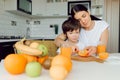 Mother and son sit in the kitchen and eat their hands. Fruit benefits concept. Healthy Eating Royalty Free Stock Photo