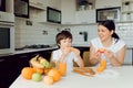 Mother and son sit in the kitchen and eat their hands. Fruit benefits concept. Healthy Eating Royalty Free Stock Photo