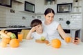 Mother and son sit in the kitchen and eat their hands. Fruit benefits concept. Healthy Eating Royalty Free Stock Photo