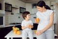 Mother and son sit in the kitchen and eat their hands. Fruit benefits concept. Healthy Eating Royalty Free Stock Photo