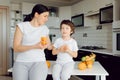 Mother and son sit in the kitchen and eat their hands. Fruit benefits concept. Healthy Eating Royalty Free Stock Photo