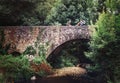 Mother and son sit on old viaduct bridge over the forest river Royalty Free Stock Photo