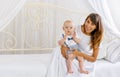 Mother with son sitting on bed and looking Royalty Free Stock Photo