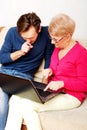 Mother and son sitting on the couch and watching something on laptop