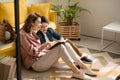 Mother and son sitting on floor at home and reading book together Royalty Free Stock Photo
