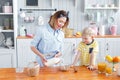 Mother and son are smiling while having a breakfast in kitchen. Mom is pouring milk and corn flakes into glass Royalty Free Stock Photo