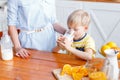 Mother and son are smiling while having a breakfast in kitchen. Mom is pouring milk into glass Royalty Free Stock Photo