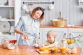 Mother and son are smiling while having a breakfast in kitchen. Mom is pouring milk into glass Royalty Free Stock Photo