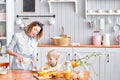 Mother and son are smiling while having a breakfast in kitchen. Mom is pouring milk into glass Royalty Free Stock Photo