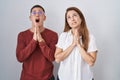 Mother and son standing together over isolated background begging and praying with hands together with hope expression on face Royalty Free Stock Photo