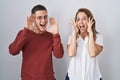 Mother and son standing together over isolated background smiling cheerful playing peek a boo with hands showing face Royalty Free Stock Photo