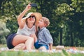 Mother with son take a selfie photo in summer park