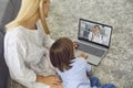 Mother with son talking to doctor online from home. Parent and little boy having video call with pediatrician on laptop