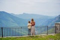 Mother and son tourists on background of Blue river running through green valley toward distant mountains. Beautiful Royalty Free Stock Photo