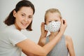 Mother and son, tries on a new protective mask. Family life in the lockdown