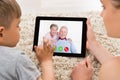 Mother And Son Videoconferencing On Digital Tablet