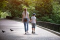 Mother and son walk in the Park. Nanny and the child. Older sister with brother. Single mother