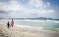 Mother and son walk on a white sand beach with turquoise waters, in Playa de Muro, Palma de Mallorca, Balearic Islands, Spain Royalty Free Stock Photo