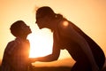 Mother and son walking on the field at the sunset time. Royalty Free Stock Photo