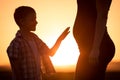 Mother and son walking on the field at the sunset time. Royalty Free Stock Photo