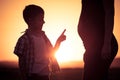 Mother and son walking on the field at the sunset time. Royalty Free Stock Photo