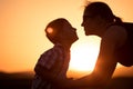 Mother and son walking on the field at the sunset time. Royalty Free Stock Photo