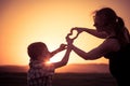 Mother and son walking on the field at the sunset time. Royalty Free Stock Photo