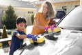 Mother and son washing car at backyard Royalty Free Stock Photo