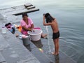 mother and son washing clothes and grooming in the sacred river Ganges Benares