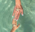 Mother and son watching starfish. Positive human emotions, feelings, joy. Funny cute child making vacations and enjoying summer. Royalty Free Stock Photo