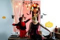 Mother and son in witch costumes and witch hats. Halloween pumpkin head jack lantern with burning candles. Secrets of