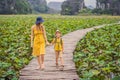 Mother and son in a yellow on the path among the lotus lake. Mua Cave, Ninh Binh, Vietnam. Vietnam reopens after Royalty Free Stock Photo