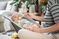 Mother spoon feeding her baby boy infant child in baby chair with fruit puree. Baby solid food introduction concept. Royalty Free Stock Photo