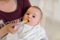 Mother with spoon feeding little baby Royalty Free Stock Photo