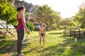 Mother sprays a child with a hose in the courtyard of the house, Boy drenched in water on a hot sunny day