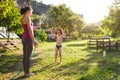 Mother sprays a child with a hose in the courtyard of the house, Boy drenched in water on a hot sunny day