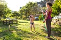 Mother sprays a child with a hose in the courtyard of the house, Boy drenched in water on a hot sunny day