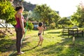 Mother sprays a child with a hose in the courtyard of the house, Boy drenched in water on a hot sunny day