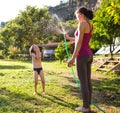 Mother sprays a child with a hose in the courtyard of the house, Boy drenched in water on a hot sunny day