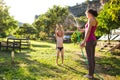 Mother sprays a child with a hose in the courtyard of the house, Boy drenched in water on a hot sunny day